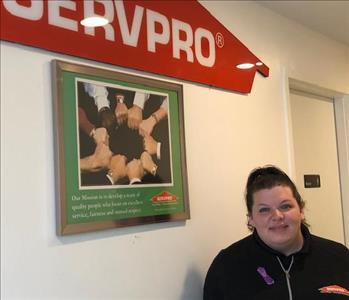 female employee standing in front of a SERVPRO sign