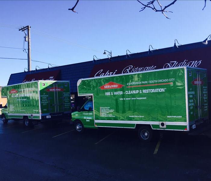 green SERVPRO box trucks sitting in front of a restaurant