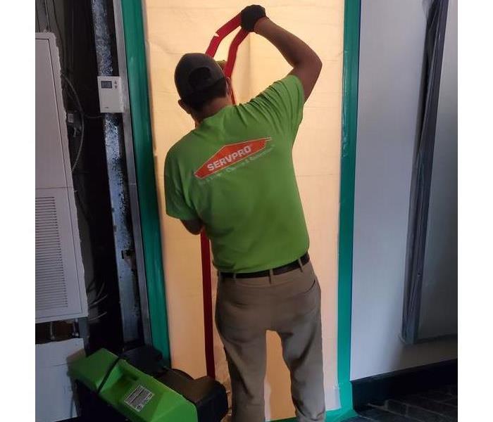 SERVPRO technician with water extraction equipment in hotel hallway