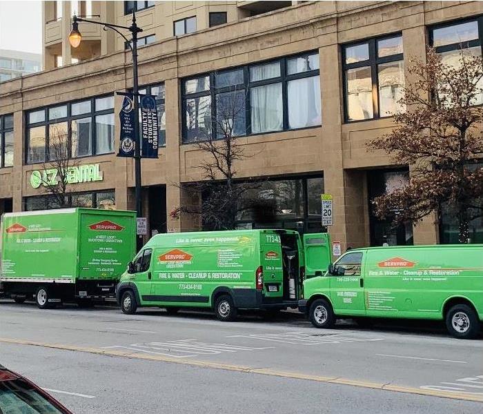 SERVPRO restoration vehicles parked on street in front of businesses