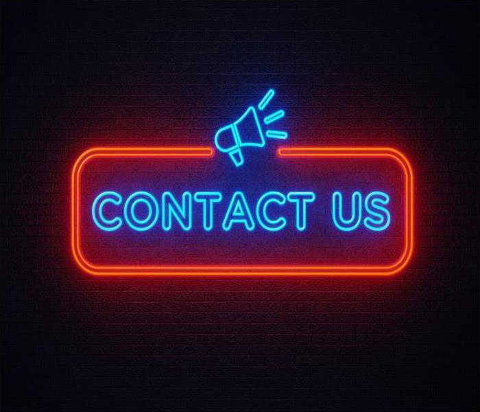 neon contact us sign on a black background