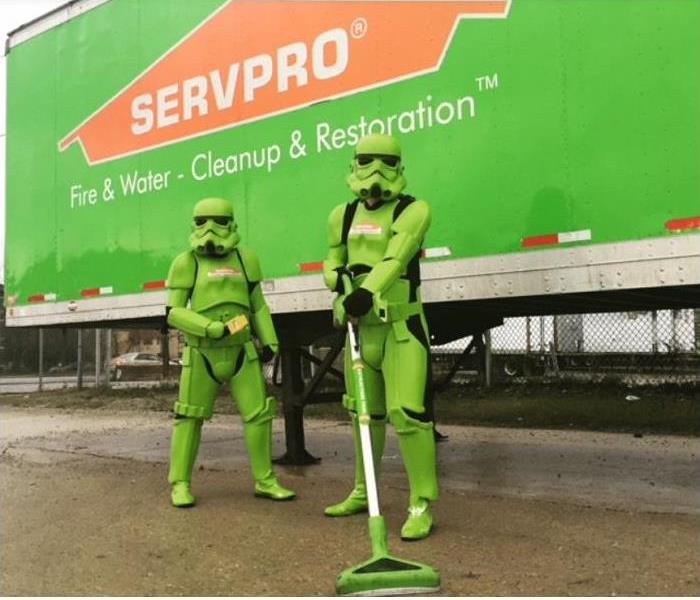 SERVPRO techs, dressed in superhero uniforms, in front of SERVPRO truck